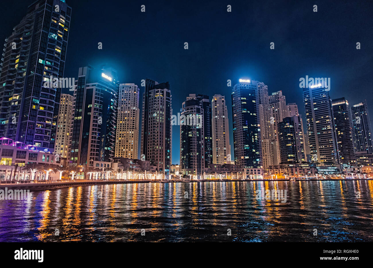 Dubai, Emiratos Árabes Unidos - Diciembre 26, 2017: el paisaje urbano de Dubai Marina District de noche. Edificios con luces del reflejo en el agua. Arquitectura o estructura y diseño. Viajes y vacaciones. Foto de stock