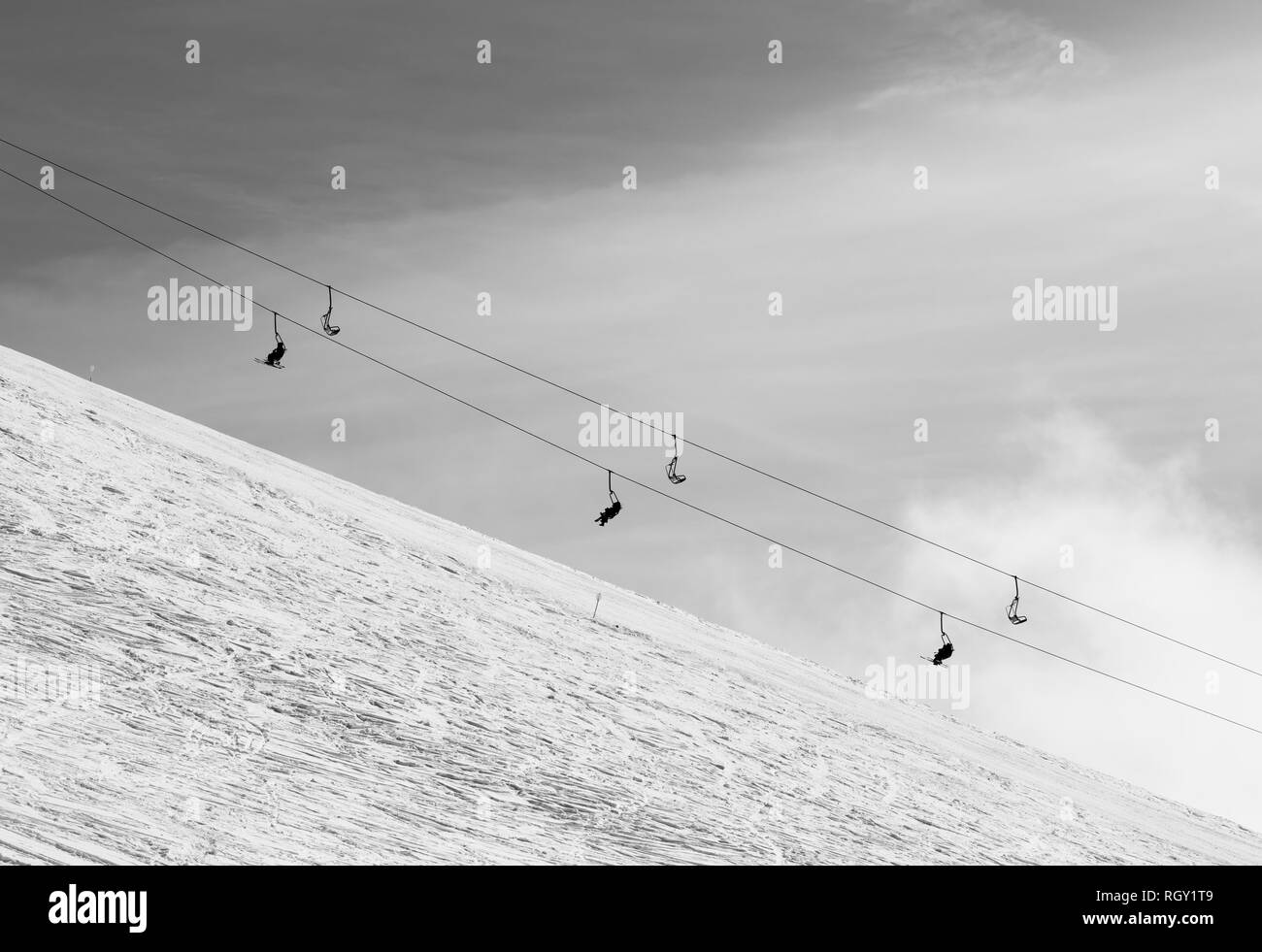 Nevados de esquí fuera de pista con trazas de esquís y snowboards y silla elevadora contra el cielo con nubes. En invierno, las montañas del Cáucaso, Georgia, la región G Foto de stock