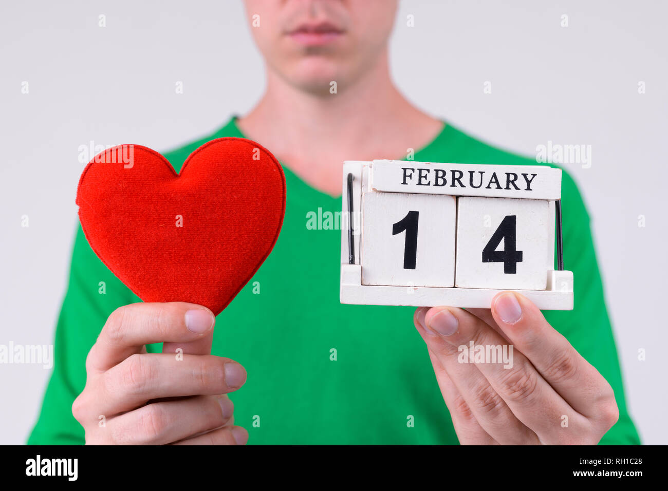 Manos de hombre joven que mantiene el bloque del calendario y el corazón listo para el día de San Valentín Foto de stock