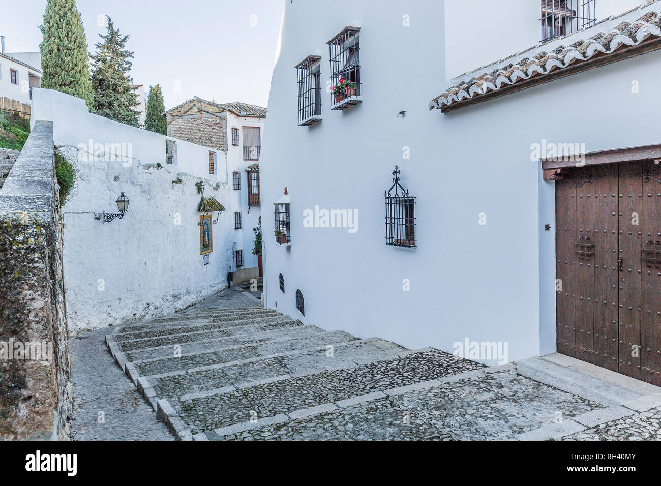 Vista de un callejón con casas con paredes blancas, ventanas de celosía  metálica, macetas con flores y puertas de madera, hoy, en la ciudad de  Córdoba España Fotografía de stock - Alamy