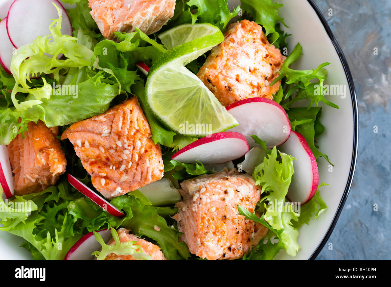 Almuerzo saludable ensalada de salmón al horno con pescado fresco, rábanos,  lechuga y limón. Vista superior Fotografía de stock - Alamy