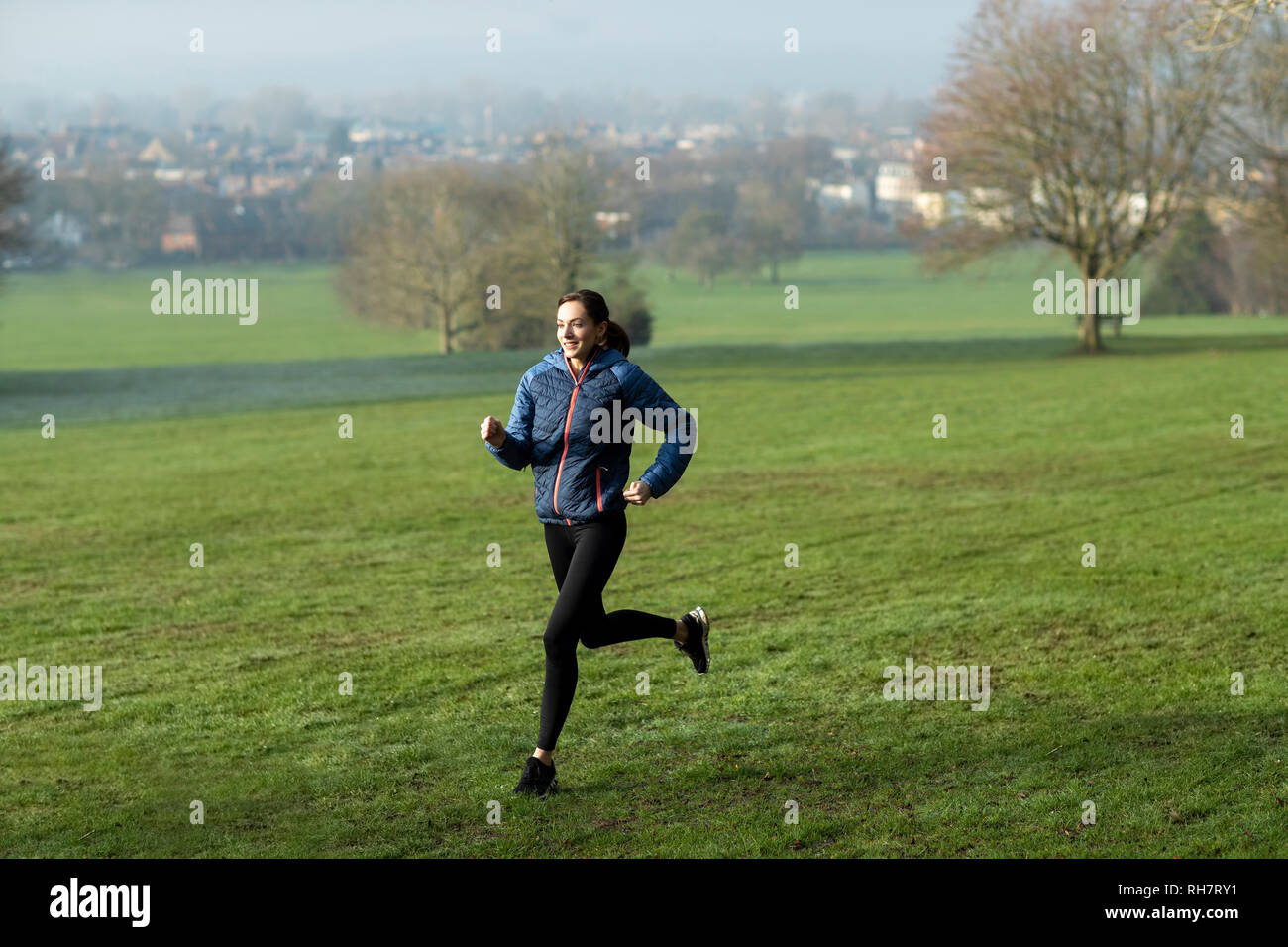 Mujer en invierno a primera hora de la mañana recorren Park mantenerse en forma haciendo ejercicio Foto de stock