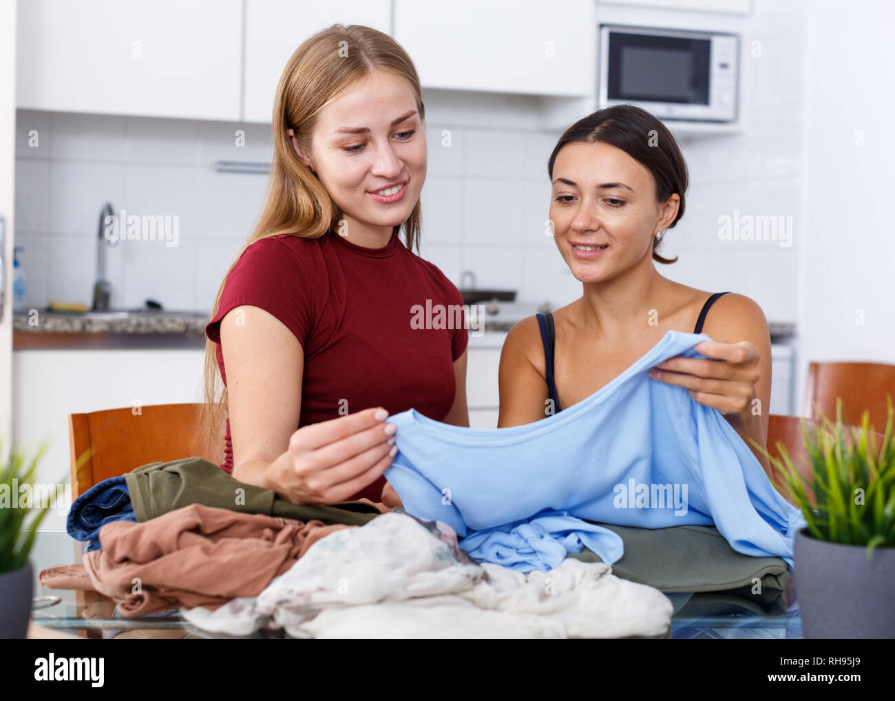 Dos amigas demostrando mutuamente y tratar la ropa interior de cocina  Fotografía de stock - Alamy