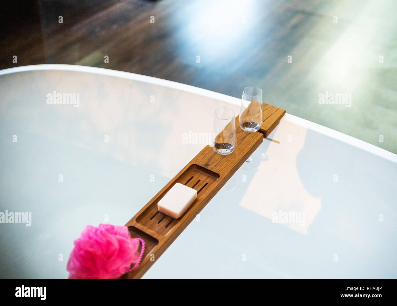 Bañera de lujo con madera barn celebración de champagne, jabón y toalla, ya que el lujo moderno interior de un apartamento diseñado por el arquitecto Foto de stock