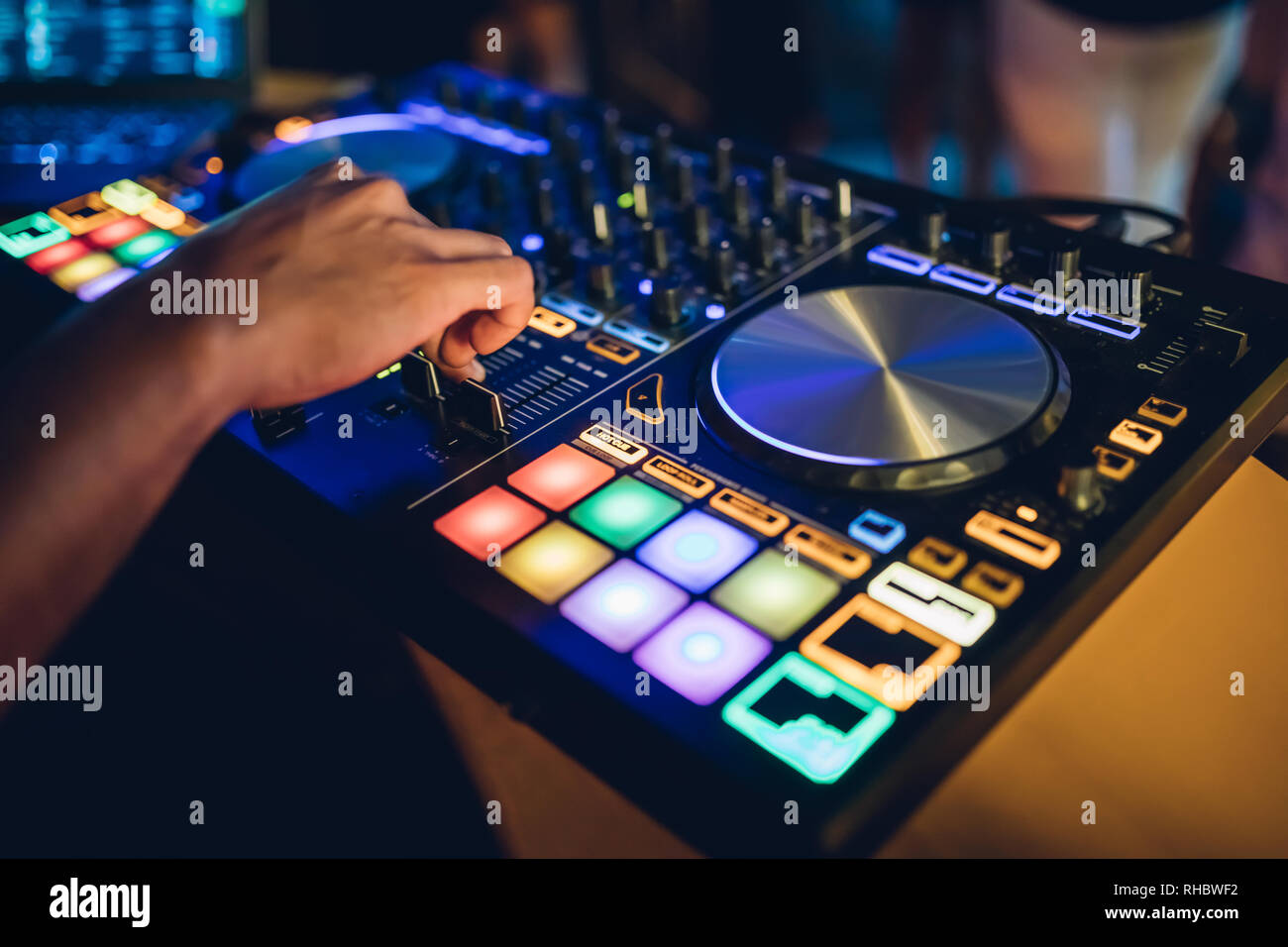DJ juega live set y mezcla de música sobre la mesa giratoria en la etapa de  la consola en el club nocturno. Disco Jokey manos en una estación de mezcla  de sonido