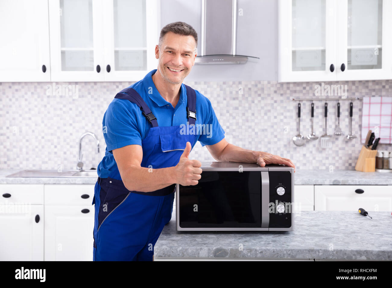 Hombre maduro, Reparación de microondas en la cocina Fotografía de stock -  Alamy