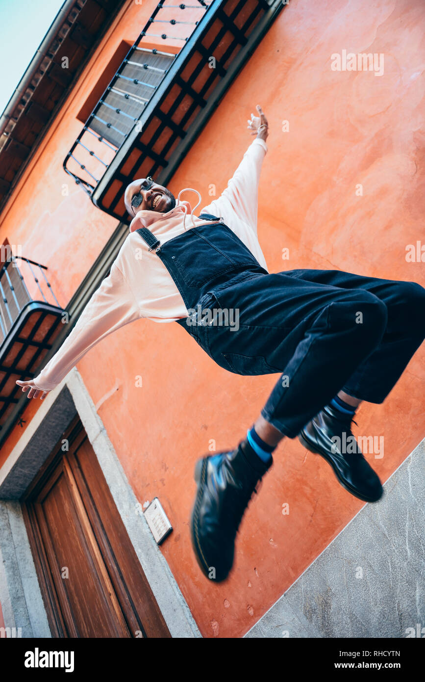 Joven negro vistiendo ropa casual saltando al aire libre Foto de stock