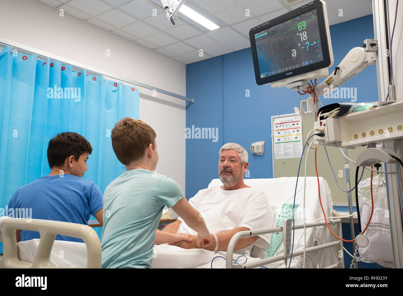 El hombre en el hospital con su familia alrededor de él Foto de stock