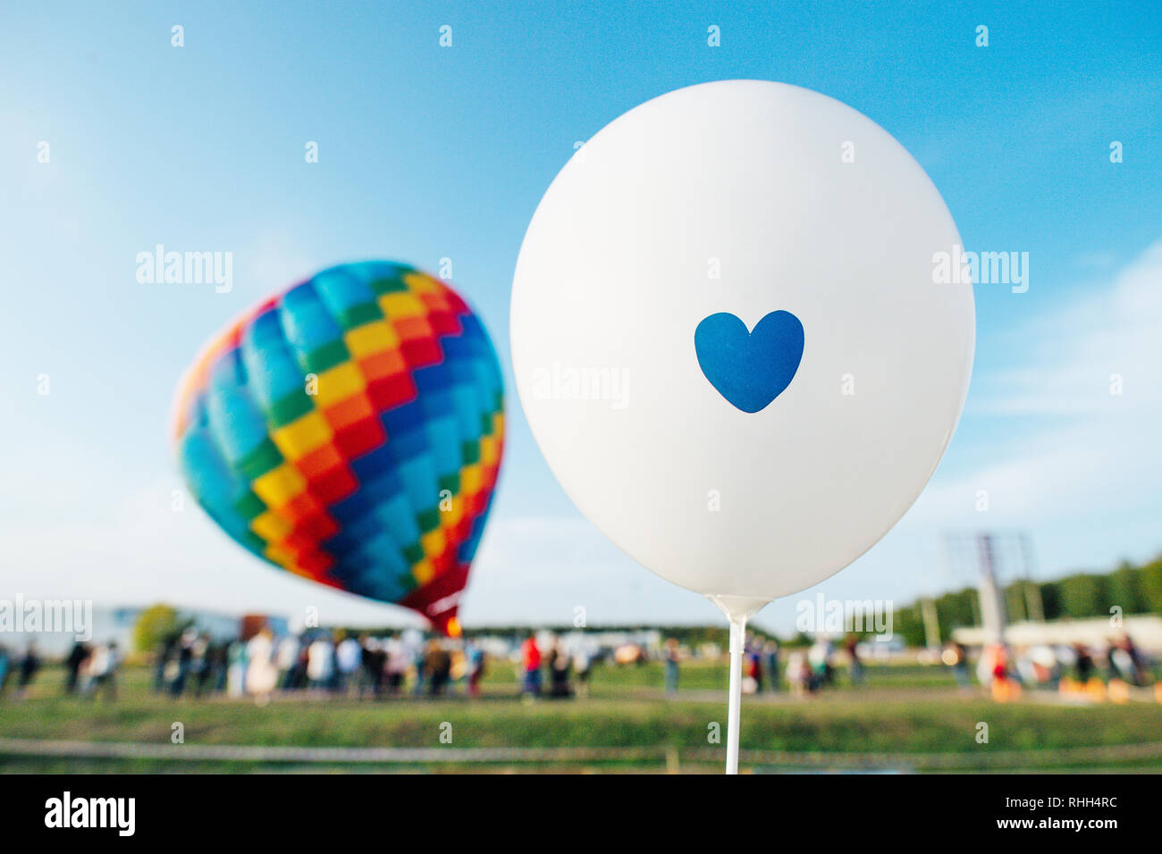 Globos de helio blancos con un corazón más borrosa que rodea gran multitud  multicolor en globo de aire caliente listo para volar en un cielo azul  claro Fotografía de stock - Alamy