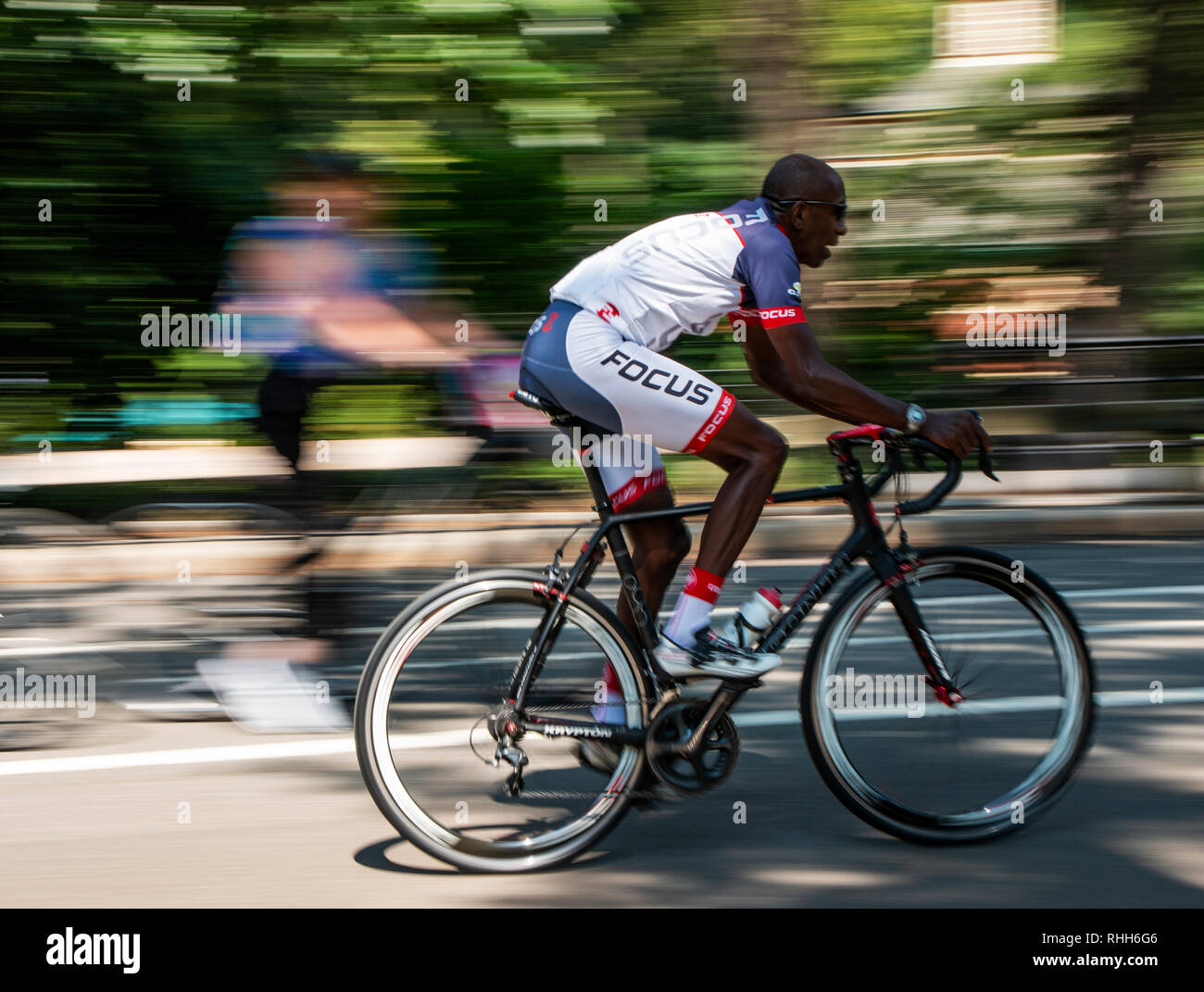 Central Park, Nueva York, Estados Unidos - 15 de agosto de 2018: un  afroamericano macho se monta su bicicleta de carreras muy rápido en la  carretera en Central park sin casco Fotografía