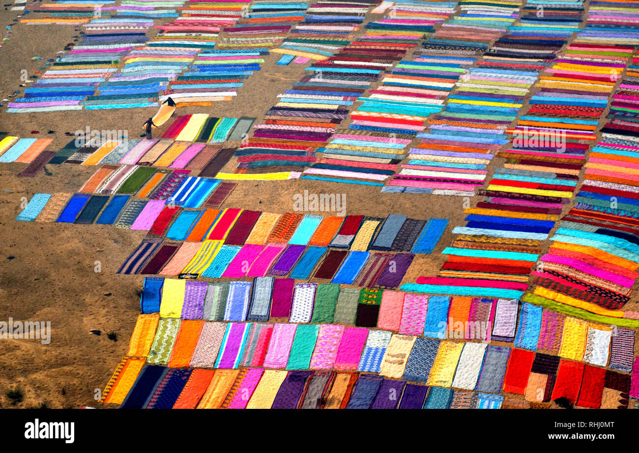 Colorida ropa de esparcirse en el suelo junto a la orilla del río de Barakar en Jharkhand área. El Dhobi Ghat (lavado) de tierra en la provincia de Jharkhand Kumardubi es el más grande en el mundo. Foto de stock