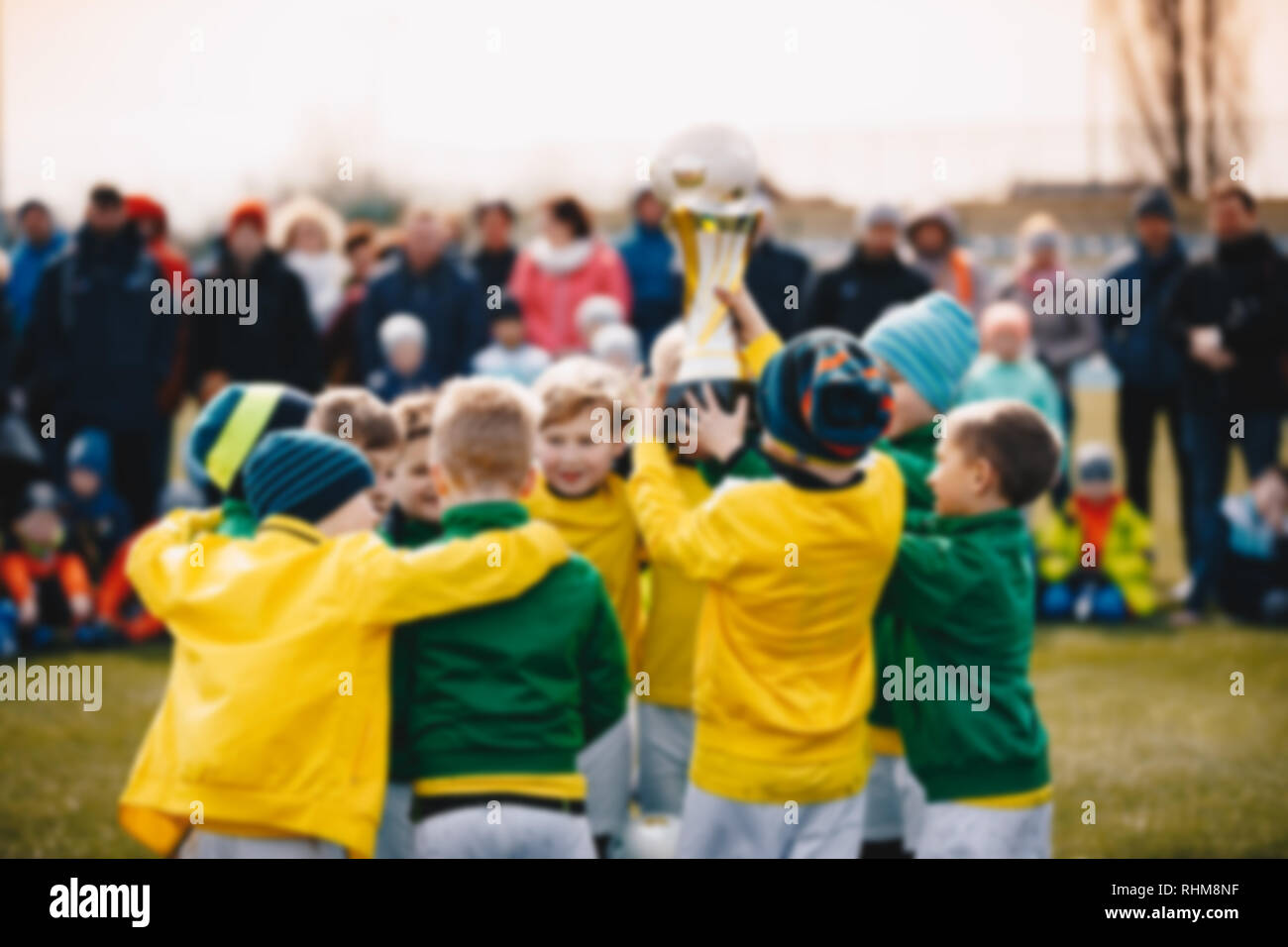 Fondo difuminado de Niños Sport Team con el trofeo. Los niños celebrando el campeonato de fútbol. Feliz jóvenes futbolistas la celebración de la Copa de Oro. Té de fútbol Foto de stock