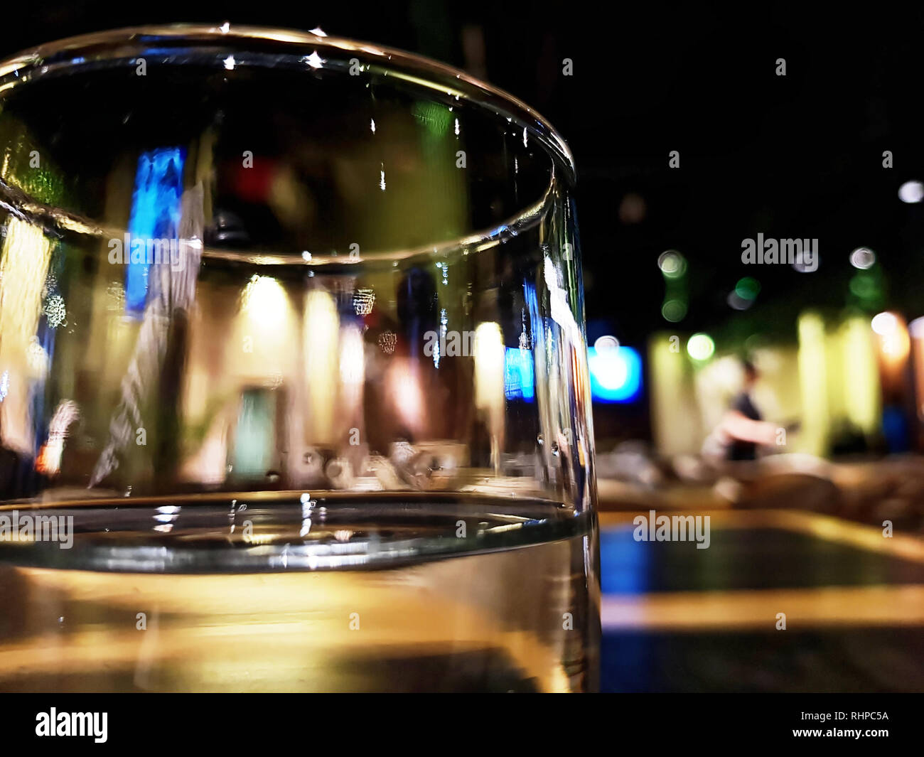 Cerrar vista a través de un vaso de agua o vino en un restaurante, con  luces borrosa en el fondo Fotografía de stock - Alamy