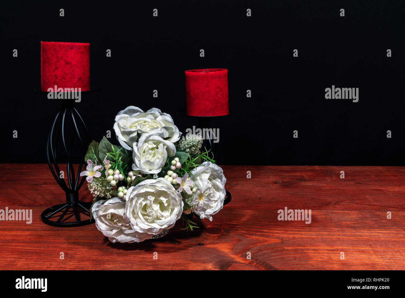 Precioso ramo de flores dispuestas sobre un soporte de velas rojas sobre una mesa de madera. El día de las madres, la Pascua, el día de San Valentín, cumpleaños, Navidad, Foto de stock