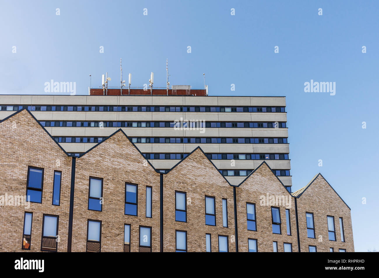 Las nuevas casas construidas a lo largo de la Calle Evans en Southampton, en contraste con un antiguo edificio en estilo brutalist arquitectura, Southampton, Inglaterra, Reino Unido. Foto de stock