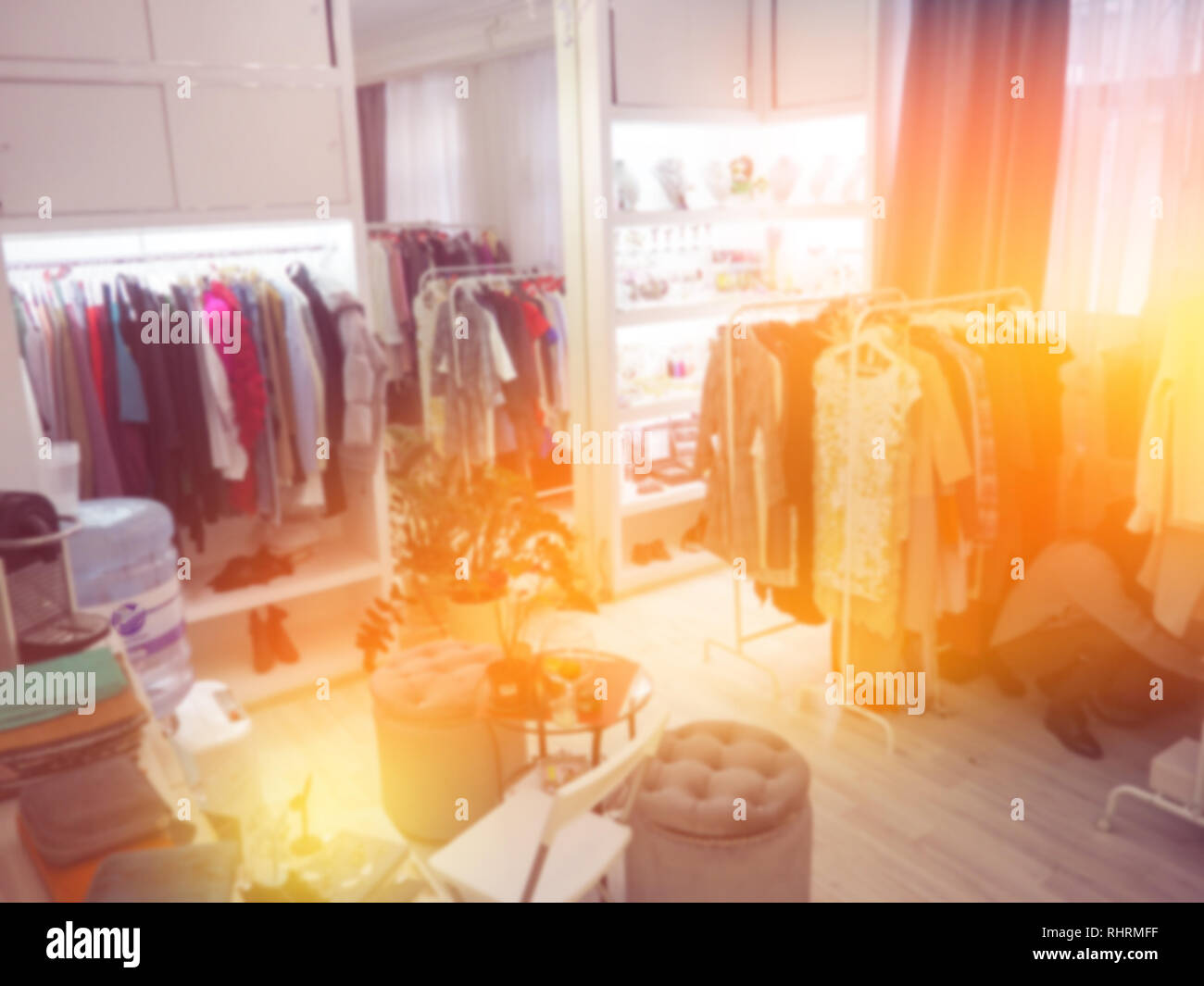 En el colgador de ropa borrosa en la tienda de ropa. Desenfoque desenfoque abstracto y centro comercial del departamento interior de la tienda de fondo. Foto de stock