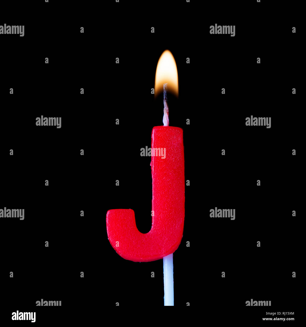 Letra J celebración vela de cumpleaños contra un fondo negro Fotografía de  stock - Alamy