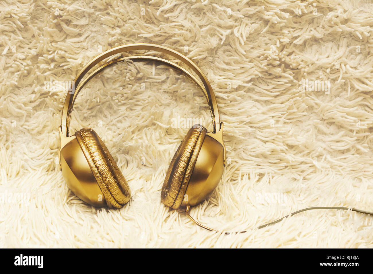 Gracioso auriculares con oro en shaggy colcha, relajación, hygge, Foto de stock