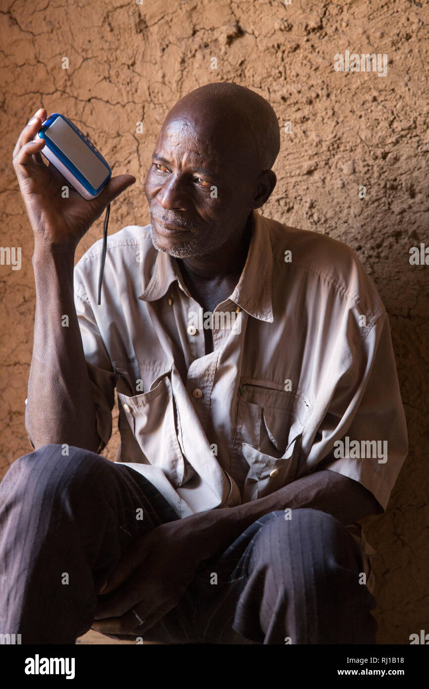 Aldea de Samba, Provincia Yako, Burkina Faso: Una casa-titular escucha a un  programa de radio de carácter educativo sobre nutrición, difundida por la  Radio Natigmbzanga local Fotografía de stock - Alamy