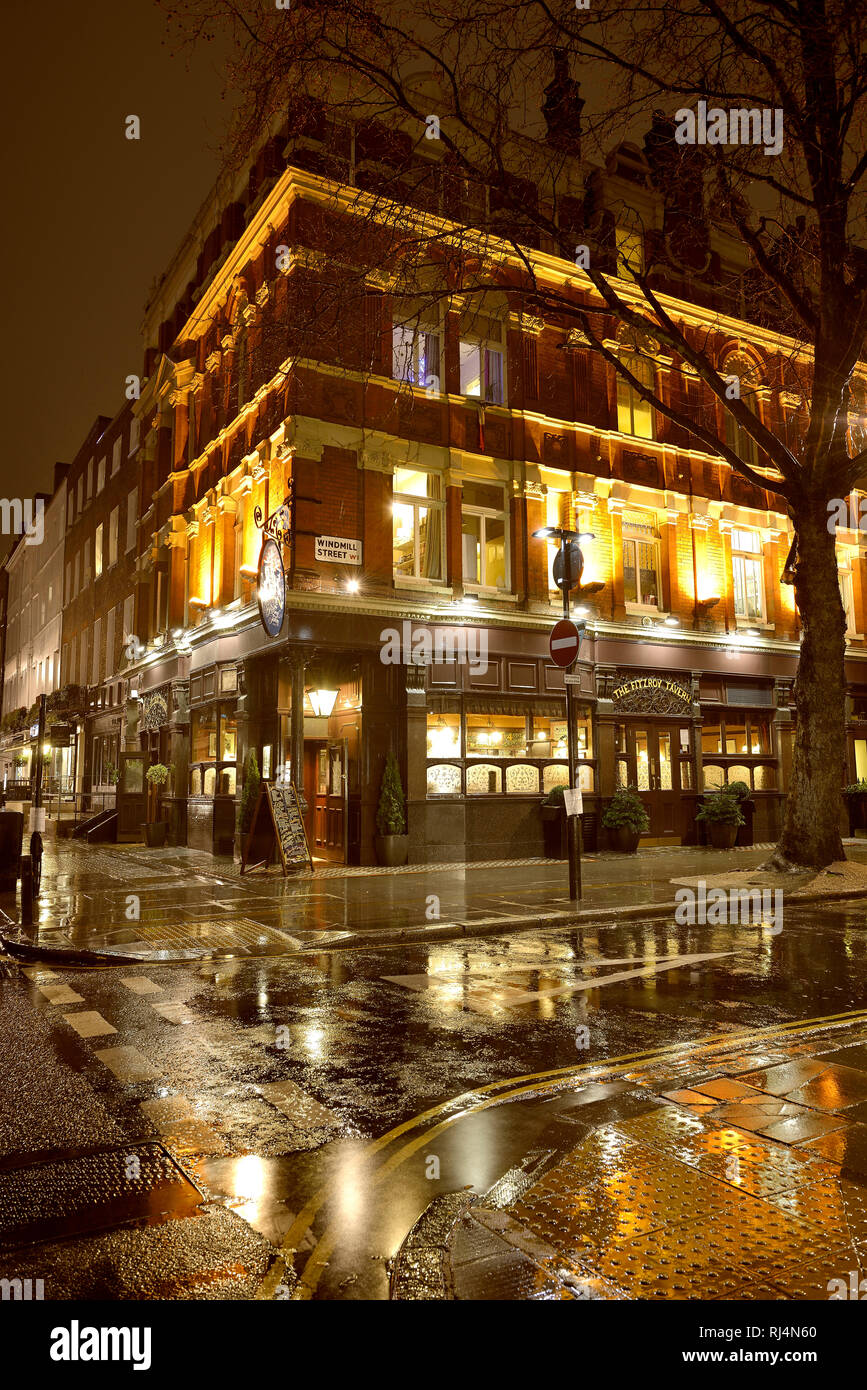 Der englische Pub La Taberna Fitzroy spiegelt sich in der nassen Straße Foto de stock