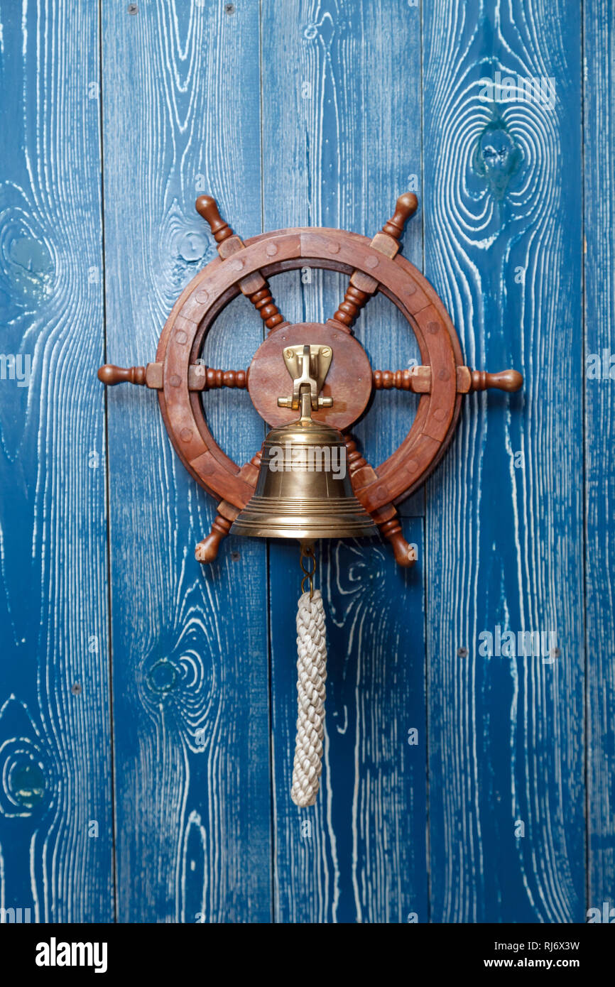 El cobre viejo vintage bell, el timbre de la puerta, la cuerda en una pared  de madera envejecida azul. Concepto de elemento de decoración en el  interior de la cubierta, camarote de