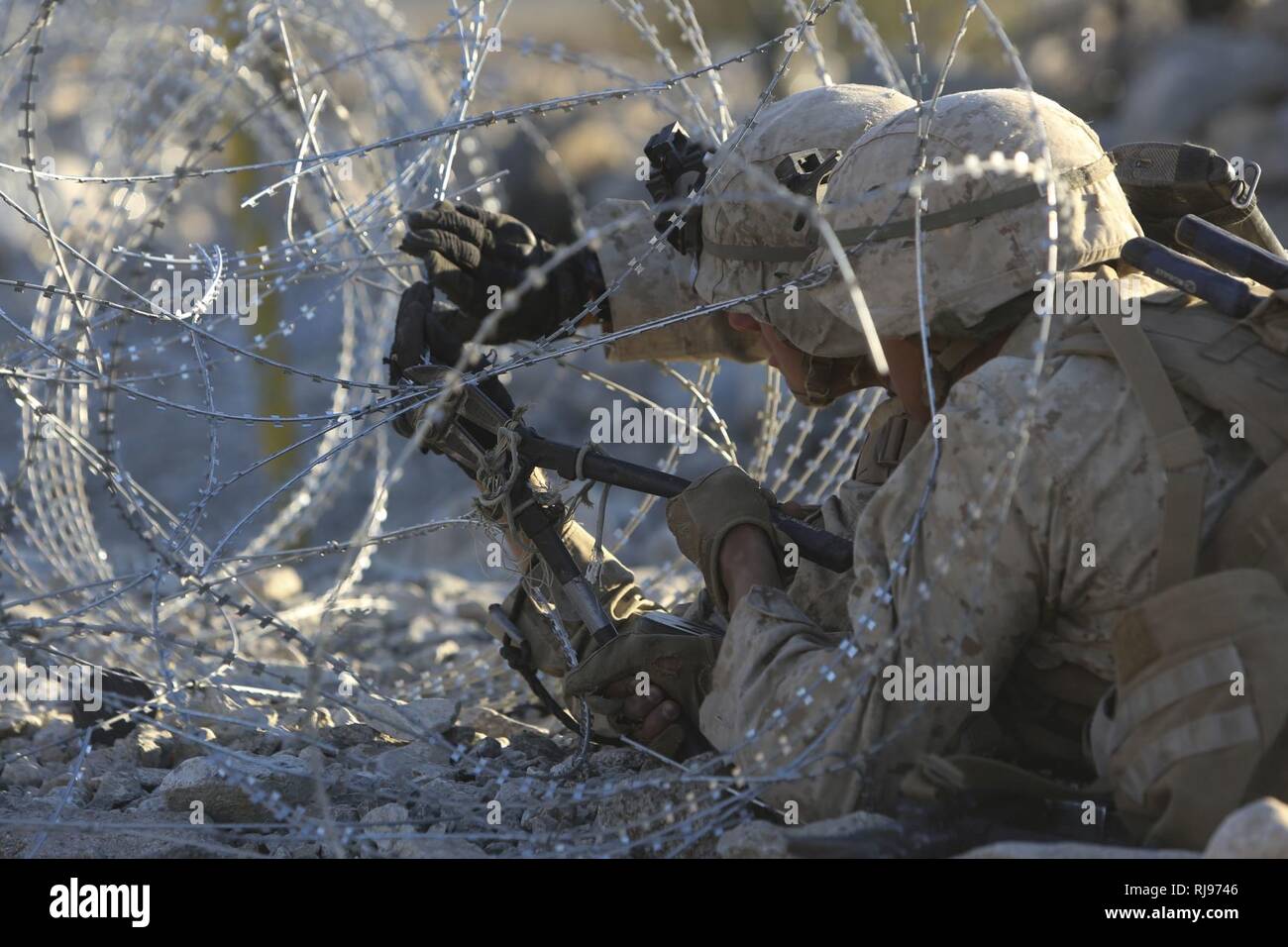 Infantes de Marina de los Estados Unidos atribuye al 3º Batallón, 5º Regimiento de la Infantería de Marina, la India Company, corte abrir una valla de alambre de púa en la Infantería de Marina Centro de combate aire-tierra 29 Palms, California Nov 4, 2016. Los Marines de 3/5 son actualmente los equipos de pruebas de campo y la tecnología desde el laboratorio de Guerra del Cuerpo de Infantería de Marina durante el ejercicio de capacitación integrado 1-17 para mejorar y mantener la competencia de armas combinadas en preparación para su implementación como el elemento de combate en tierra para la 31ª Unidad Expedicionaria de los Infantes de Marina. (Infantería de Marina de Estados Unidos Foto de stock