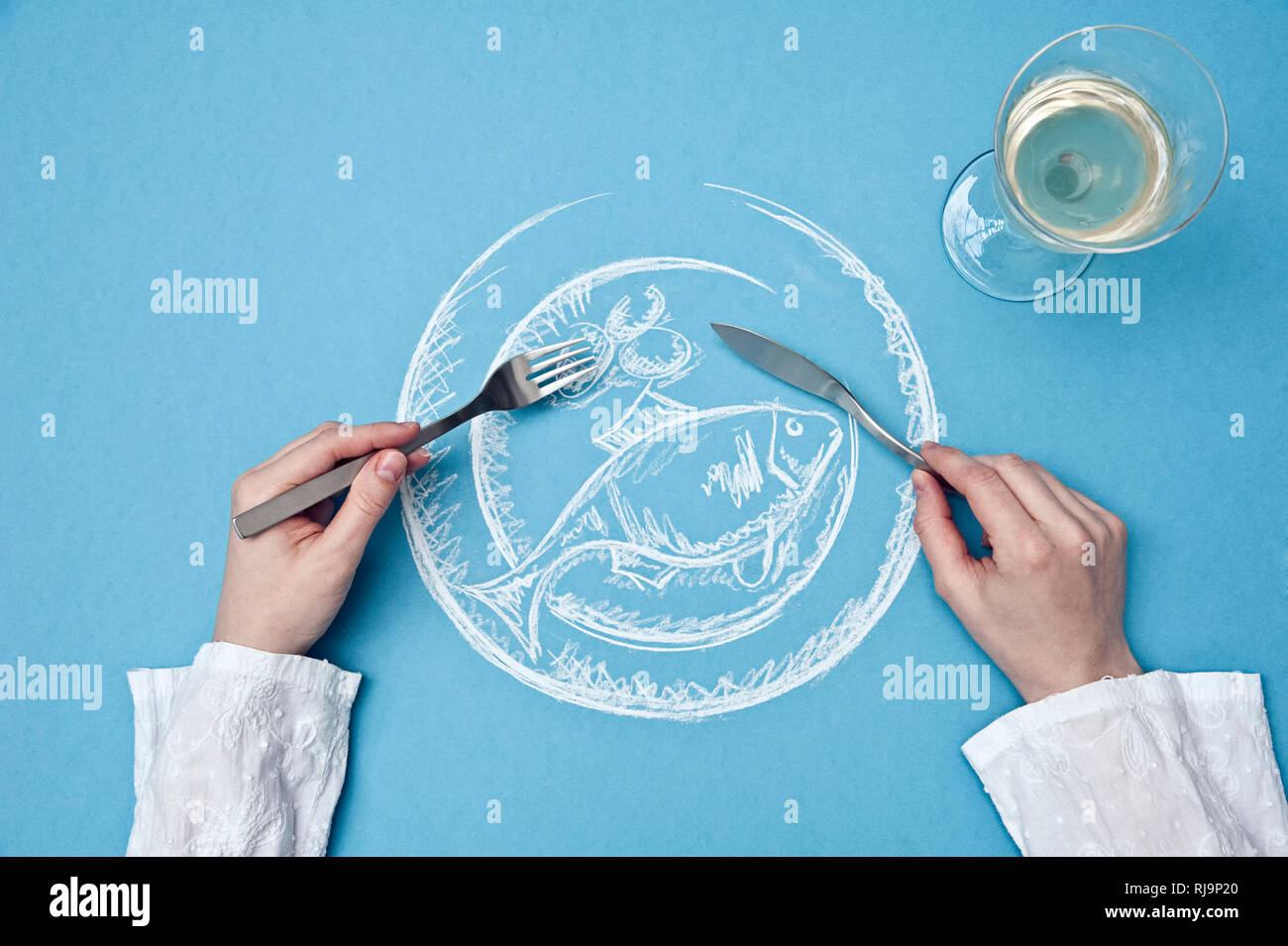 Eines Zeichnung Fischtellers aus der Vogelperspektive, Eine persona hält Messer und Gabel über den Teller, Foto de stock