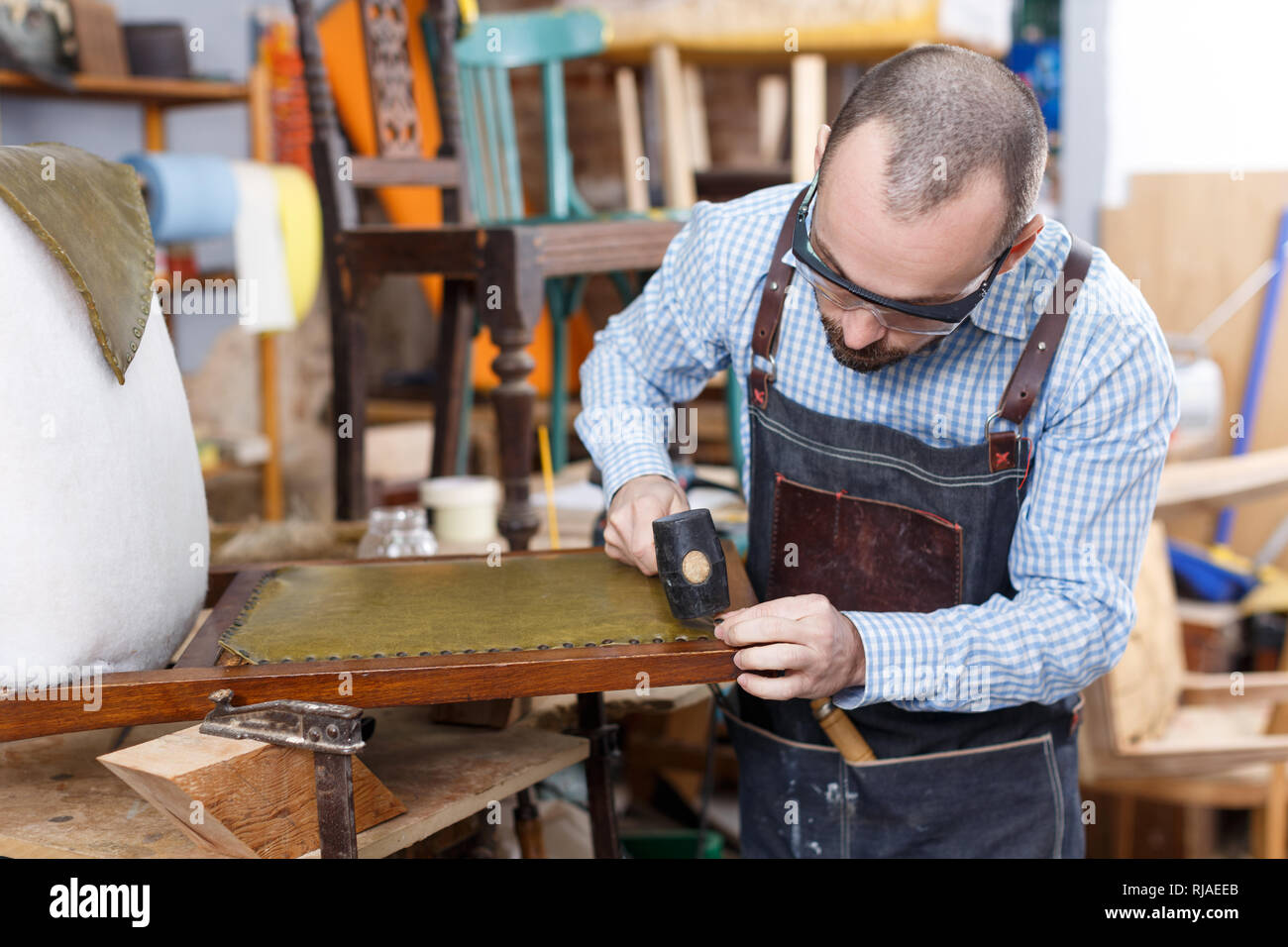 Restaurador de muebles profesional en proceso de renovación vintage sillón  en el taller Fotografía de stock - Alamy