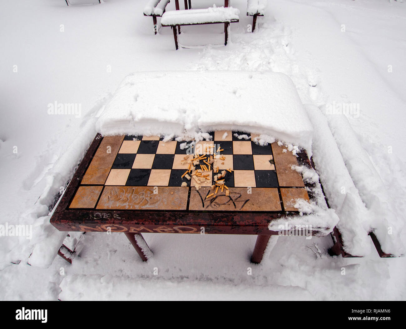 LODZ, Polonia- 4 de febrero de 2019: un tablero de ajedrez al aire libre cubierto de nieve. Foto de stock