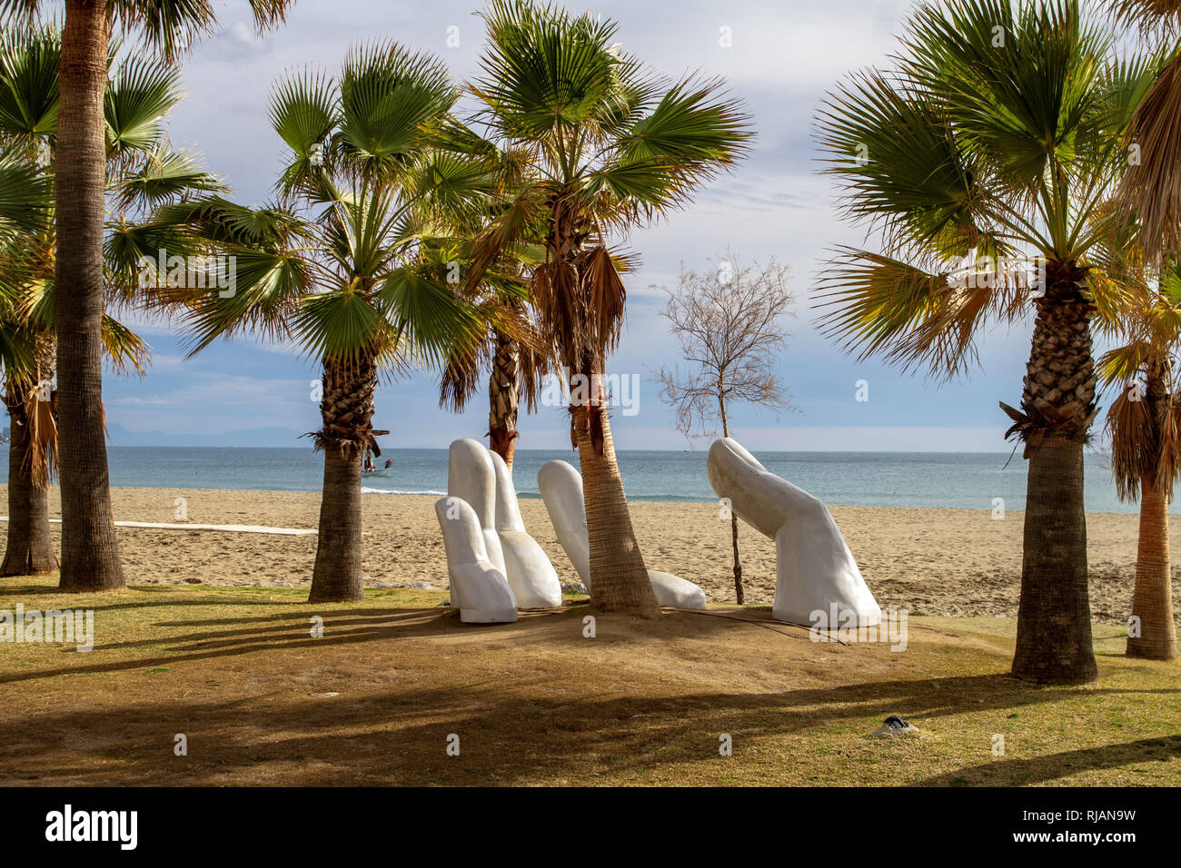 Los Boliches, España. La escultura a mano abierta de Charo García erigida en 2015 e incrustada en palmeral en la playa de los Boliches, España. Foto de stock