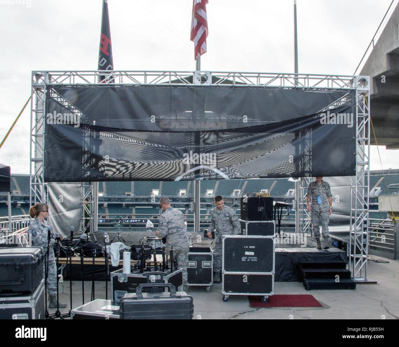 Los miembros del grupo de música rock "Movilidad" de la banda de la Fuerza  Aérea de los EE.UU del Golden West descargar equipos para su espectáculo  del medio tiempo de la Liga