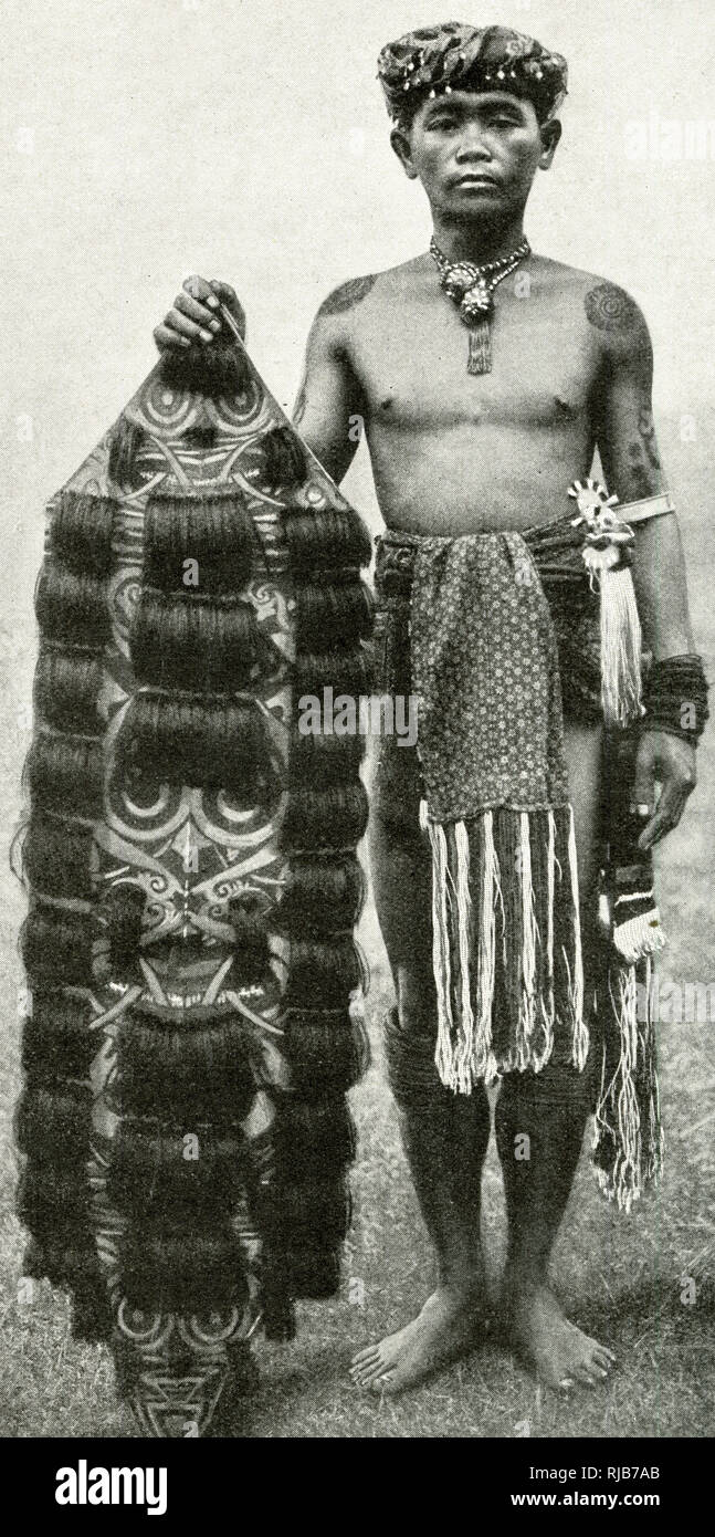 Kenyah hombre con su escudo, Borneo, sudeste de Asia Foto de stock