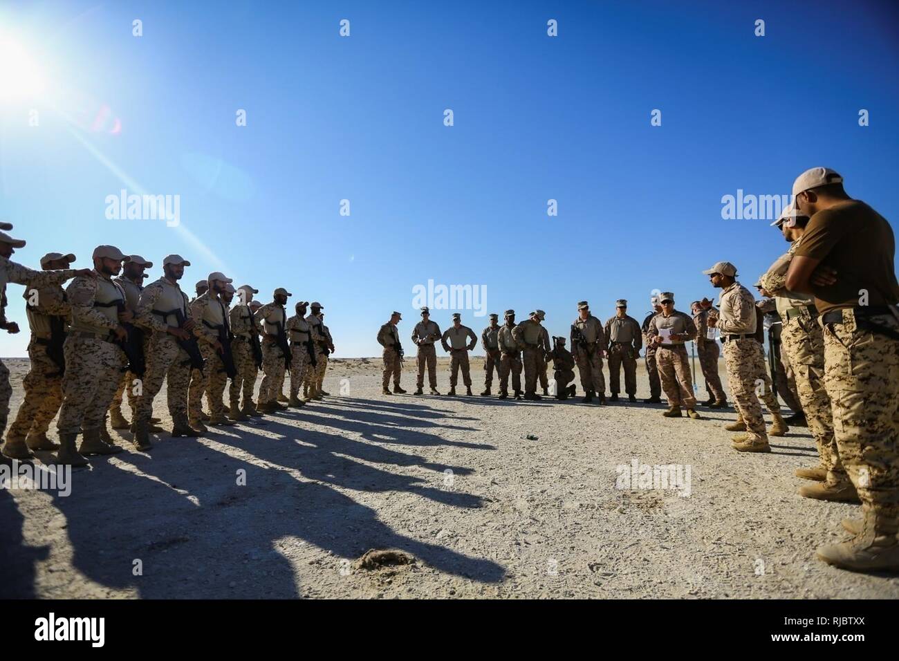 Bahrein (Ene. 14, 2018) Un soldado de la Fuerza de Defensa de Bahrein interpreta instrucciones de Marines adjunta a la flota de equipo de seguridad contra el terrorismo, el Comando Central, un subordinado el mando de la Fuerza Naval Anfibia, Task Force 51, 5ª Brigada Expedicionaria de la Marina - TF 51/5, antes de llevar a cabo Close Quarters Battle la capacitación. TF 51/5 personal participa con frecuencia en el experto en la materia de intercambio con los países socios para compartir la experiencia en sus campos respectivos y aprovechar las capacidades de la nación partners con el fin de aumentar la estabilidad regional y mejorar la interoperabilidad. Foto de stock