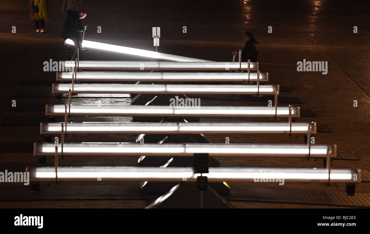 Un par disfrutar cabalgando sobre el iluminado y ver musicales-sierras de la instalación de arte titulada Wave-Field, Variación F, que se ha instalado en la caída del carbón yardas detrás de la estación de tren de Kings Cross en Londres central. Foto de stock