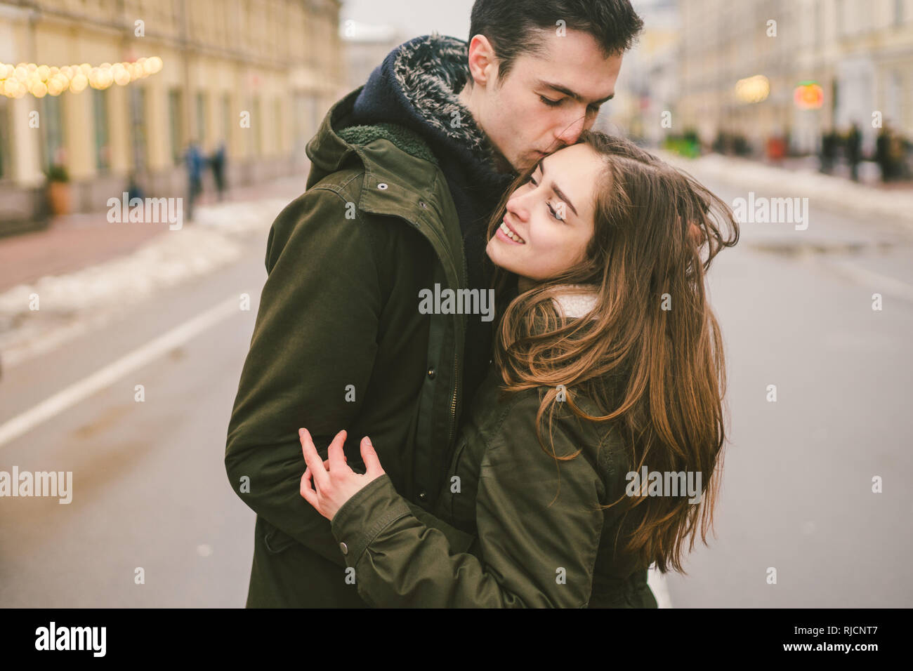 Tema el amor y el romance. Los jóvenes caucásicos pareja heterosexual en el amor estudiantes novio chica abrazos y besos en el centro de la carretera en el centro de Foto de stock