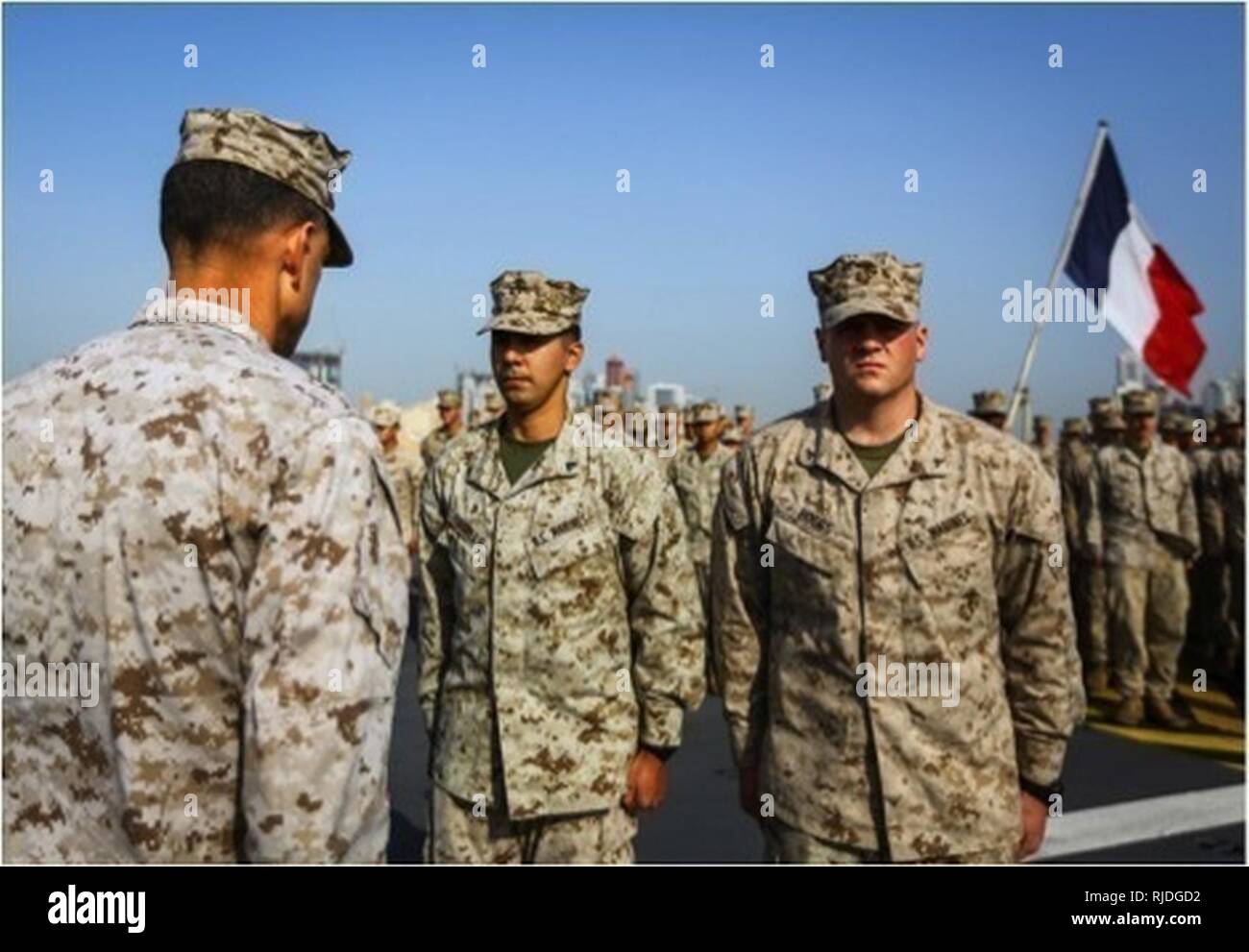 5ª Flota de EE.UU. ZONA DE OPERACIONES (Ene. 20, 2018) 15ª Brigada Expedicionaria de la Marina la Cpl. Martin Trujillo, centro y Lance Cpl. Jordania Boggs, derecha, se preparan para recibir la Marina y el Marine Corps logro medallas de Brig. Gen. Francisco L. Donovan, comandante de la Fuerza Naval Anfibia, Task Force 51, 5ª Brigada Expedicionaria de la Marina (TF 51/5), a bordo del buque de asalto anfibio francés IZD Tonnerre (L 9014). Tonnerre, iniciado con los Marines y marineros de TF 51/5 está realizando operaciones de seguridad marítima dentro de los EE.UU. 5ª Flota de la zona de operaciones para garantizar la estabilidad regional, la libertad de navegación Foto de stock