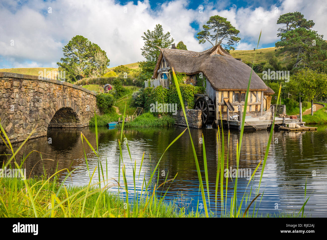 MataMata, Nueva Zelandia - Marzo 2017 Hobbit house y el antiguo molino junto a un antiguo puente de grava Hobbiton Foto de stock