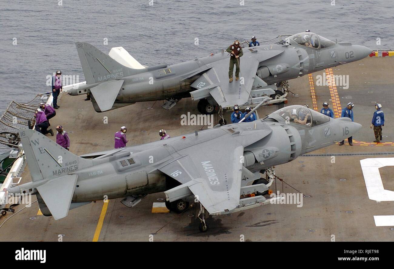 US Navy (USN) los combustibles de aviación (púrpura) y el plano de manejadores (azul) de combustible marineros US Marine Corps (USMC) AV-8B Harrier II, Marina 214 Escuadrón de ataque (VMA-214), Blacksheep, Marine Corps Air Station (MCAS) Yuma, Arizona (AZ), antes del lanzamiento de la clase Tarawa USN Buque de asalto anfibio USS PELELIU (LHA-5). PELELIU es actualmente en curso en el Océano Pacífico la realización de transportista calificaciones. Foto de stock