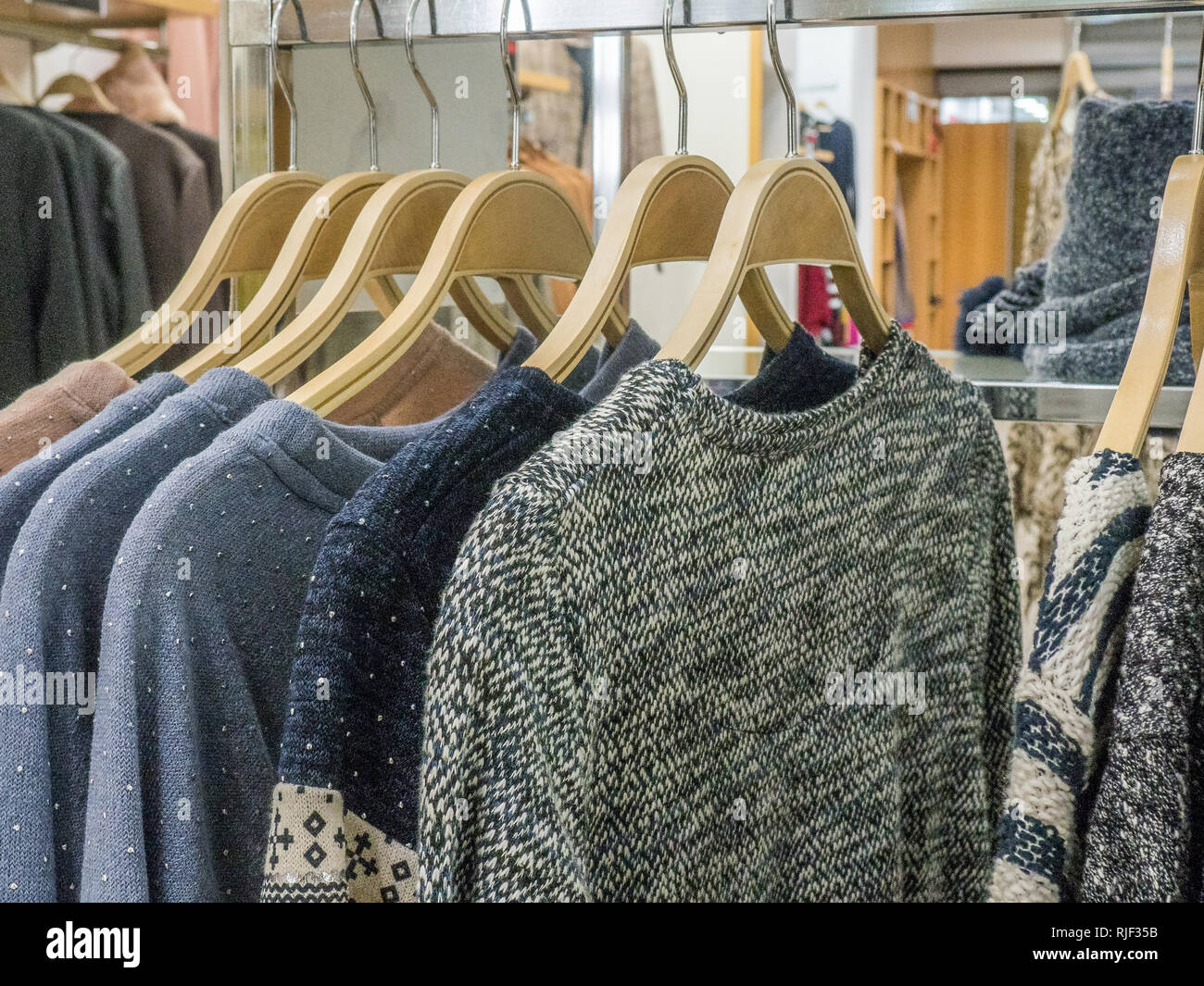 Suéteres en un estante en la tienda de moda Foto de stock