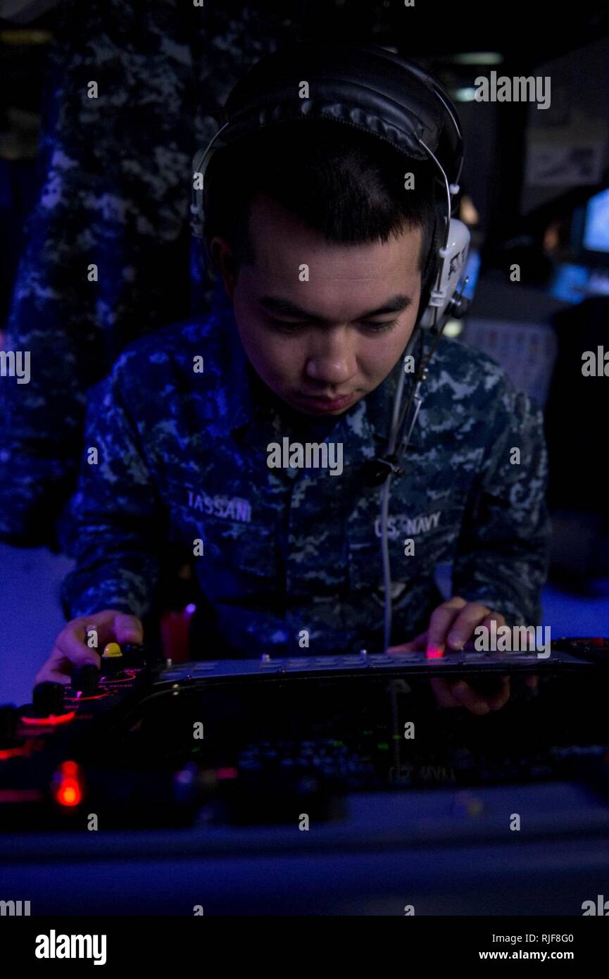 Mar de Filipinas (Abril 3, 2013), especialista en operaciones marino Peter Tassani superficie pistas de contactos en el SPA-25G pantalla de radar en el centro de información de combate a bordo de la clase Arleigh Burke de misiles guiados destructor USS McCampbell (DDG 85) durante un ejercicio de guerra anti-submarina. McCampbell es parte de Destroyer Squadron (DESRON 15), desplegadas a Yokosuka, Japón, para apoyar a la seguridad regional y la estabilidad de la región del Pacífico Indo-Asia. Foto de stock