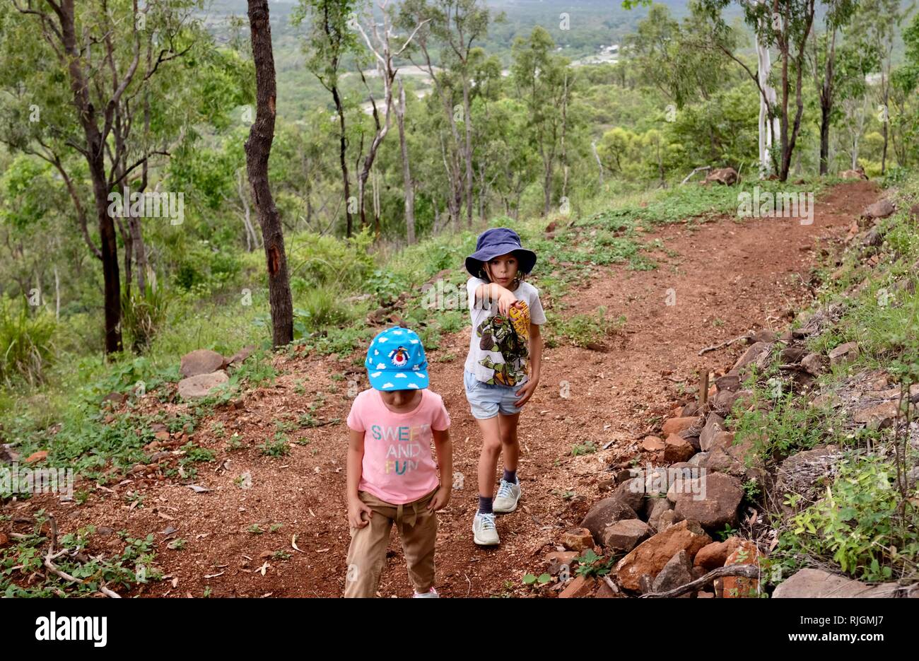 Los niños en edad escolar a caminar por una pista de tierra, Moongun sendero en Elliot Springs, Townsville, Queensland, Australia Foto de stock
