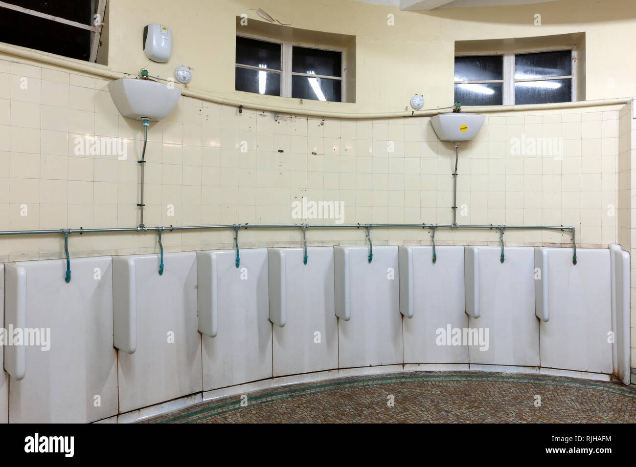 Fila de caballeros baño público urinarios. Foto de stock