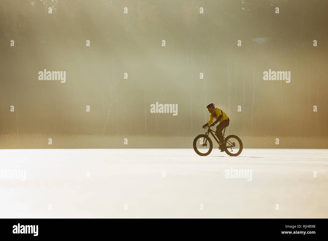Hombre ciclismo sobre un lago congelado Foto de stock