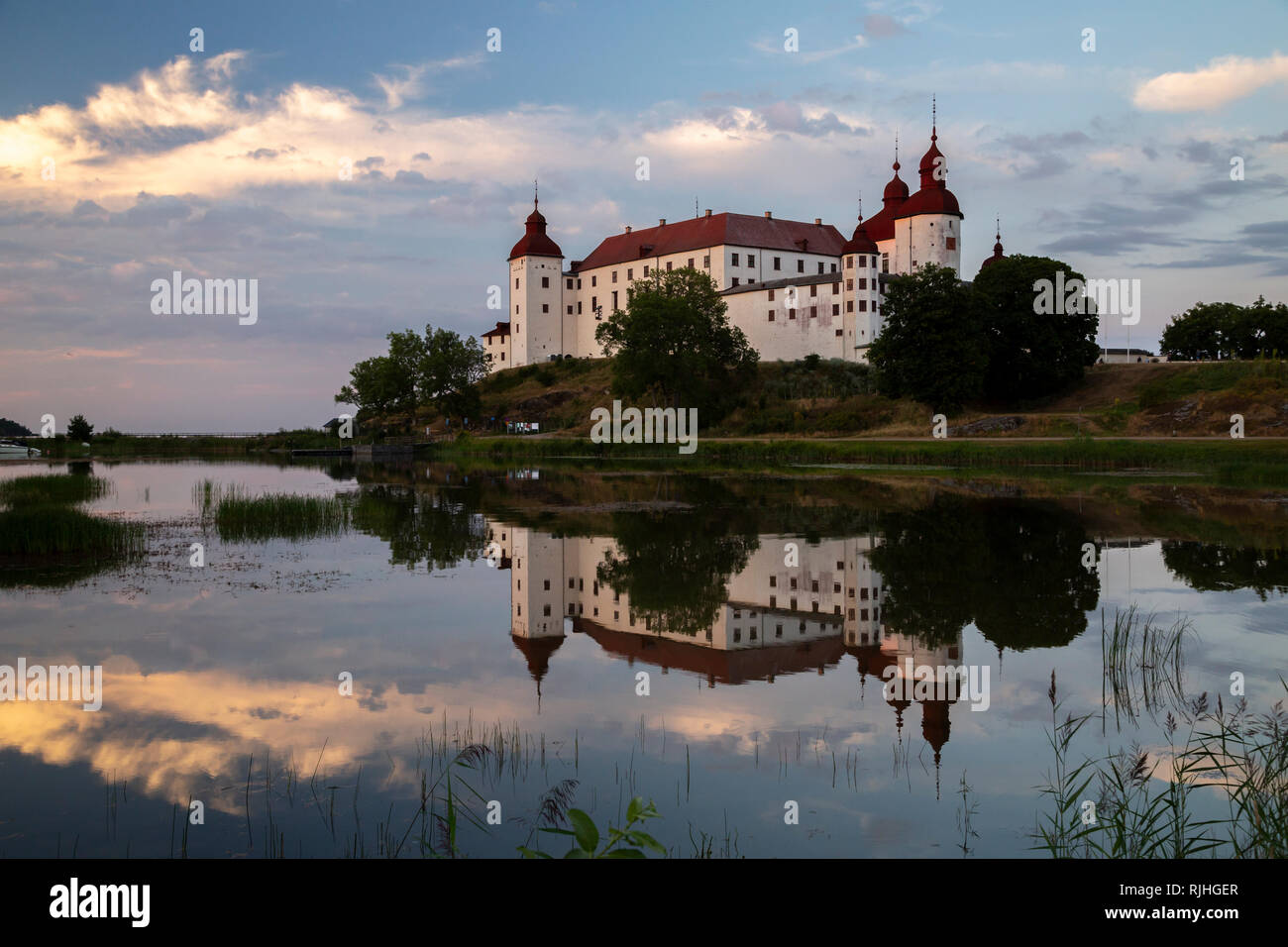 Noche de filmación castillo Lacko con reflejo en el espejo como el agua del lago Vanern, Lidköping, Suecia Foto de stock