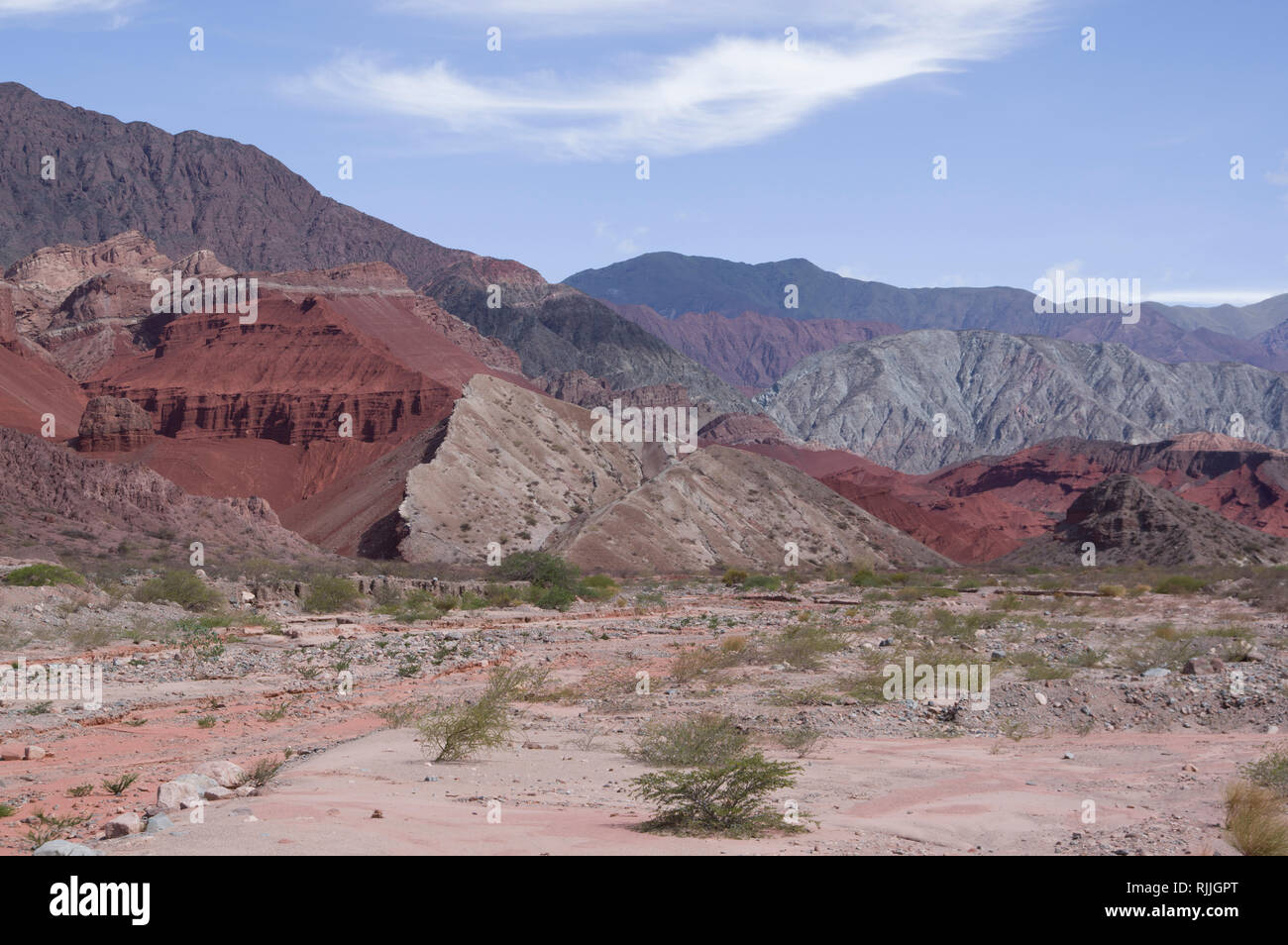 El llamativo hermoso paisaje desértico en el norte de Argentina, cerca de Salta y Juyjuy con mesetas de arenisca roja ríos y coloridos cerros Foto de stock