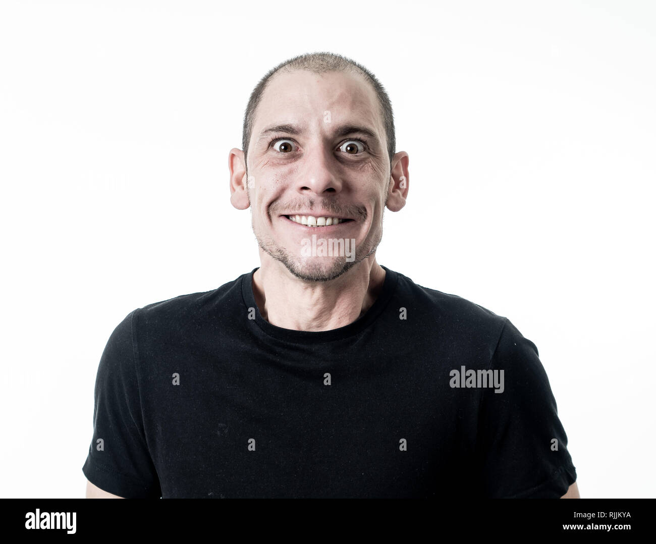 Cara feliz y expresiones faciales. Close Up retrato de alegre sonriente joven adulto hombre emocionado gesticulando gracioso y cómico de la risa, aislado en WH Foto de stock