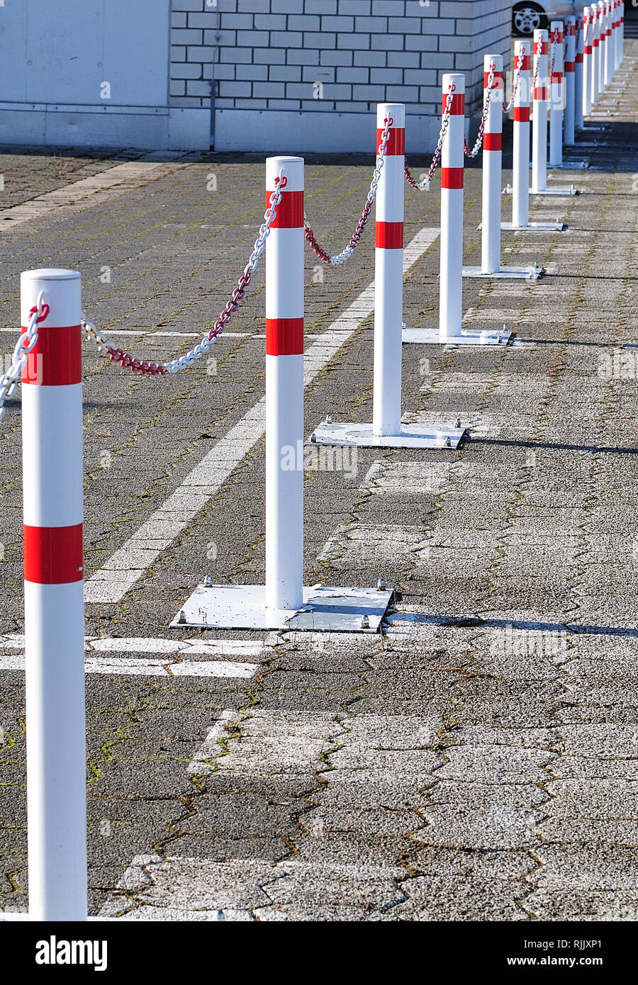 Límite en un parking con postes metálicos interconectados con cadenas  Fotografía de stock - Alamy