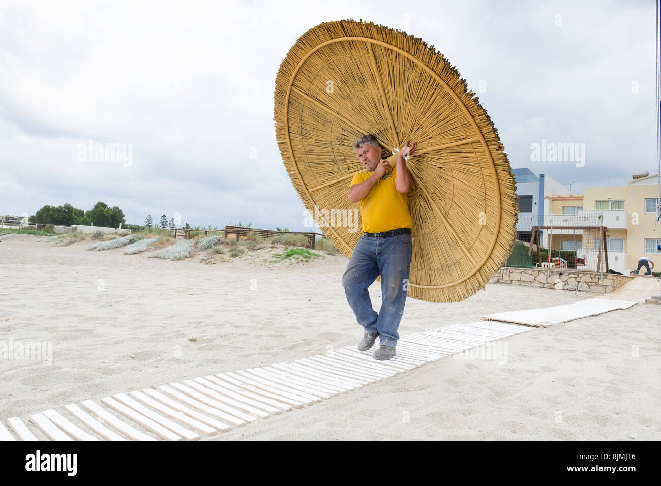 Adelianos Kambos en Creta: El obrero lleva una nueva sombra para la playa Foto de stock