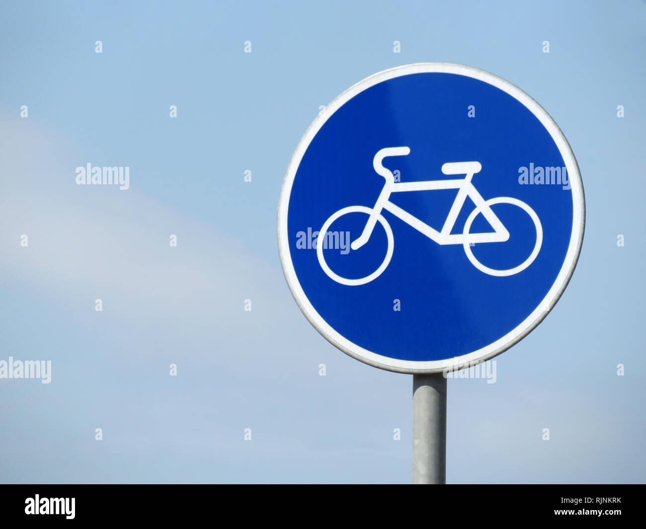Señal de carretera bicicleta aislado sobre un cielo azul. Símbolo de  bicicletas blancas en el círculo azul de firmar Fotografía de stock - Alamy