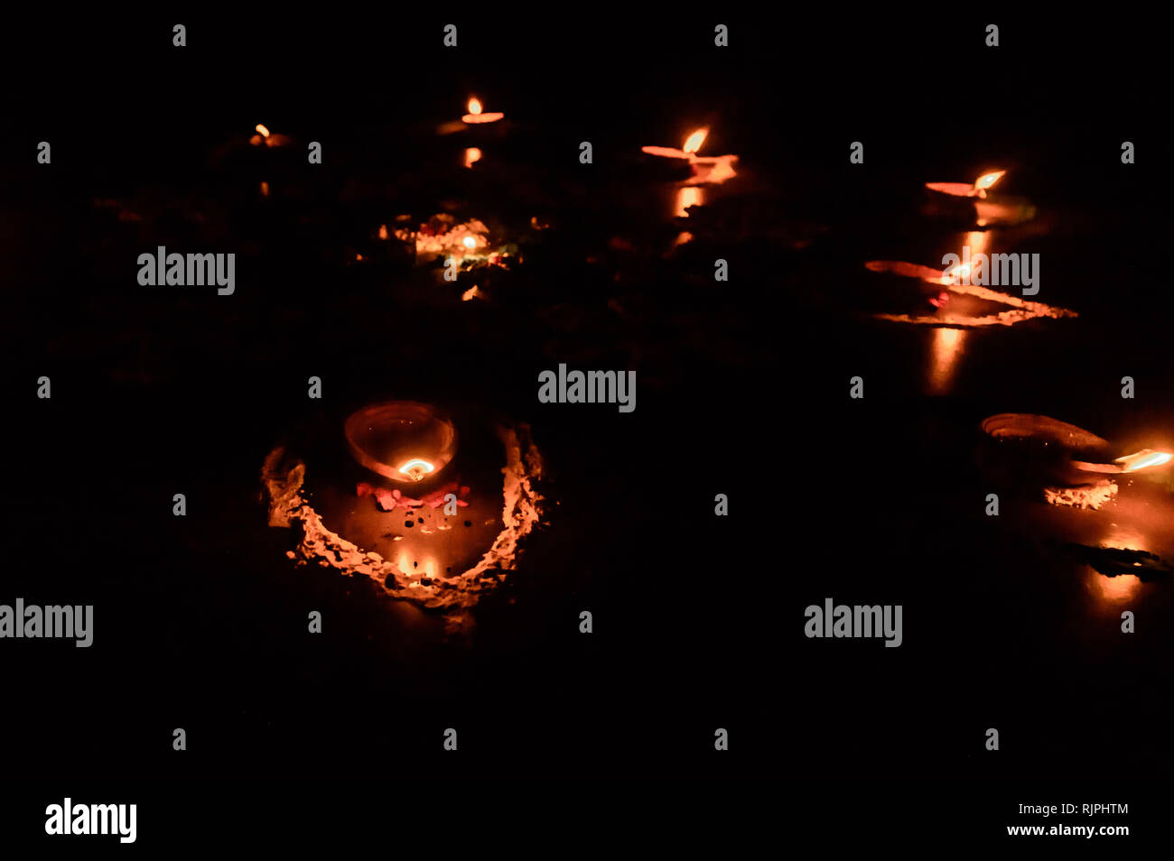 Diya- lámparas encendidas en la temporada del festival de Diwali. Grupo de  lámpara de aceite quemado sobre fondo negro. Iluminación de velas en la  oscuridad. Velas encendidas con real volver Fotografía de
